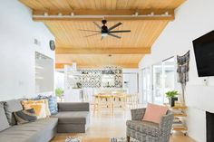 a living room filled with furniture and a flat screen tv mounted on the wall next to a fire place