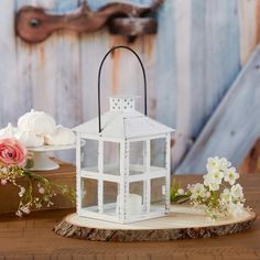 a small white lantern sitting on top of a wooden table