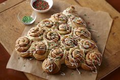 a bunch of doughnuts that are sitting on a wooden table with sprinkles