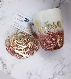 two coffee mugs sitting on top of a marble counter next to a package of confetti