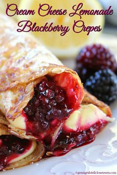 crepes filled with berries and cream cheese are on a plate next to fruit