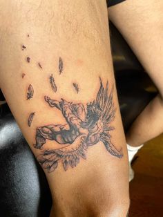 a tattoo on the leg of a man with flowers and birds flying around it,