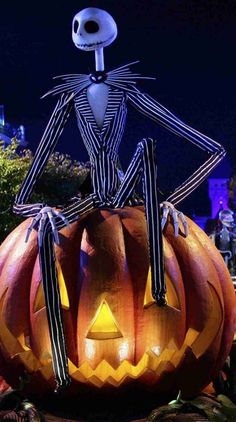 a jack - o'- lantern pumpkin with a skeleton sitting on it