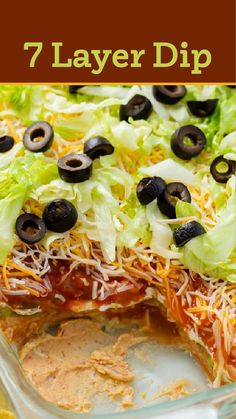 a layered pizza with cheese, lettuce and olives on top in a casserole dish