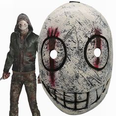 a creepy looking mask with two holes in the middle and a man standing next to it