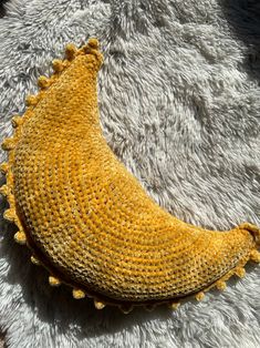 a crocheted banana sitting on top of a white rug