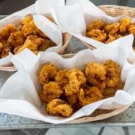 four baskets filled with fried food on top of a table