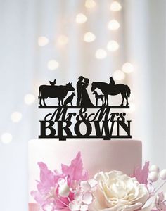 a wedding cake topper that says mr and mrs brown on it, with flowers in the foreground