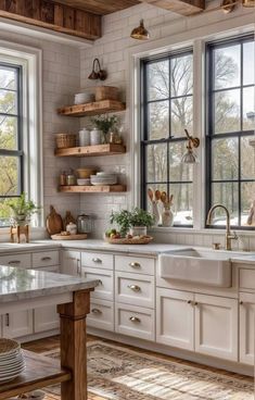 a kitchen filled with lots of white cabinets and counter top space next to two windows