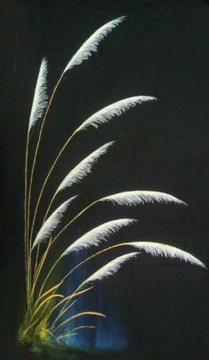 some white flowers are in a vase on a black table top with the light from behind them