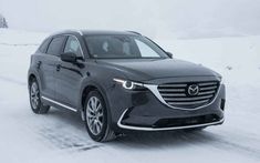 the new mazda cx - 9 is driving on a snowy road