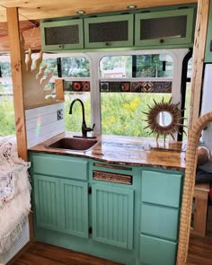 a kitchen with green cabinets and a sink