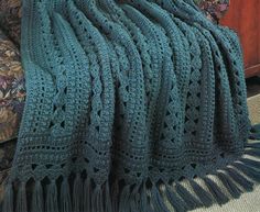 a crocheted blanket is draped on a couch