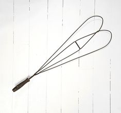 a metal object hanging from the side of a white wall