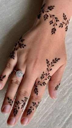 a woman's hand with henna tattoos on it