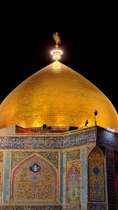 the dome of an ornate building lit up at night