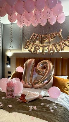 balloons and streamers fill the air above a bed in a bedroom decorated for a 21st birthday