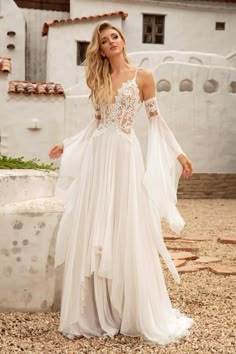 a woman in a white wedding dress posing for the camera with her hands on her hips