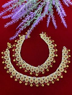 This kundan payal anklet set is perfect for adding a touch of class to any look. Crafted from a gold plated base, it features maroon beads and bells, crystal beads, and comes in a pair for a complete look. Perfect for bridal events or everyday wear. Traditional Gold Beaded Anklets, Traditional Anklets For Puja And Festive Occasions, Kundan Anklets With Latkans For Festivals, Temple Jewelry Toe Ring Anklets For Festivals, Festive Temple Jewelry Anklets With Latkans, Festive Temple Jewelry Toe Ring Anklet, Beaded Toe Ring Anklets For Festivals, Festive Toe Ring Anklets For Rituals, Festive Kundan Anklets With Stone Work