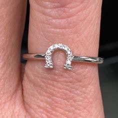 a woman's hand with a diamond ring on top of her finger and the letter o in the middle