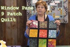 a woman holding up a piece of art quilt