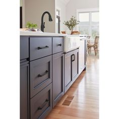 a kitchen with wooden floors and gray cabinets