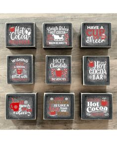 six square coasters with holiday sayings on them, sitting on top of a wooden table