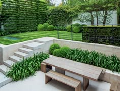 a wooden bench sitting in the middle of a lush green yard with steps leading up to it