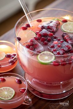 two glasses filled with cranberry punch and garnished with limes