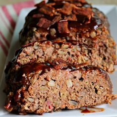 two slices of meatloaf sitting on top of a white plate covered in ketchup