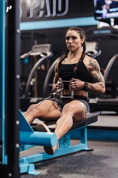 a woman sitting on top of a bench in a gym