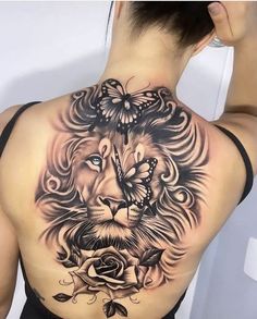 a woman's back with a lion and butterfly tattoo on her upper half sleeve