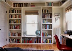 a room filled with lots of books next to a window