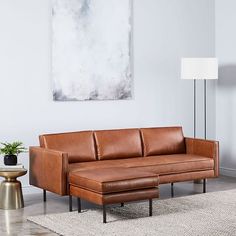 a brown leather couch sitting on top of a rug