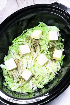 a bowl filled with lettuce and cubed cheese