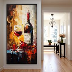 a wine bottle and two glasses on a table in front of a painting by the door