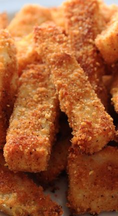 some fried food on a white plate with parmesan cheese and seasoning sprinkles