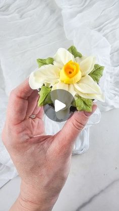 a person holding a fake flower in their hand