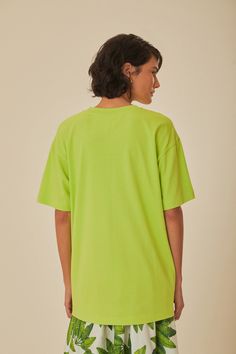 Immerse yourself in tropical vibes with the Green Sounds Like Brasil Organic Cotton T-Shirt by FARM Rio. This vibrant piece features a lively round neckline and a relaxed fit that drapes effortlessly for a comfy yet stylish feel. The bright green hue serves as a canvas for a playful parrot graphic, encapsulated with bold, lively text, offering a burst of Brazilian spirit. Crafted from soft organic cotton, this tee invites a touch of nature's comfort to your everyday wardrobe. Composition 100% COTTONCare Instructions MACHINE WASH, GENTLE CYCLE, DO NOT BLEACH, DO NOT TUMBLE DRY, LINE DRYING, IRON AT MEDIUM HEAT, DRY CLEAN WITH ANY SOLVENT EXCEPT TRICHLOROETHYLENESize and Fit Inches XXS XS S M L XL Bust 40 2/4 42 2/4 44 2/4 46 2/4 49 2/4 52 2/4 Waist 40 3/4 42 3/4 45 46 3/4 49 3/4 52 3/4 Leng Green Oversized Short Sleeve Tops, Oversized Green Short Sleeve Top, Green Relaxed T-shirt For Loungewear, Lime Green Cotton Tops For Summer, Casual Lime Green Tops For Summer, Casual Lime Green Summer Tops, Green Graphic Tee For Summer, Green Crew Neck T-shirt For Summer, Green Relaxed Fit T-shirt For Summer