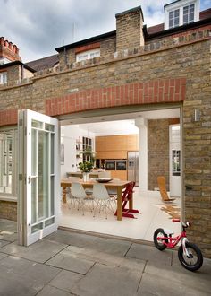 a bike is parked in front of a brick building with an open patio and dining area