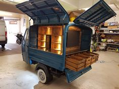 a small blue truck with its doors open