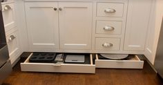 an open drawer in the middle of a kitchen