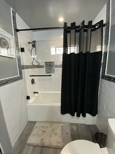 a bathroom with black and white shower curtains