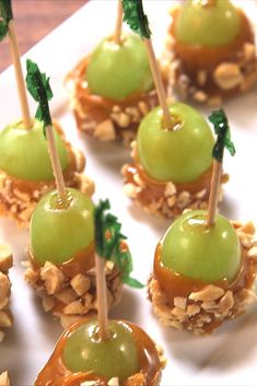 some food is on a white plate and has green apples in the middle with leaves