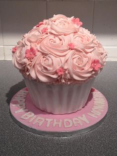 a birthday cupcake with pink frosting and roses