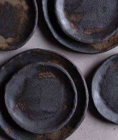 four dirty black plates sitting on top of a counter