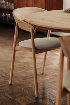 a wooden table with two chairs next to it on a hard wood floored floor