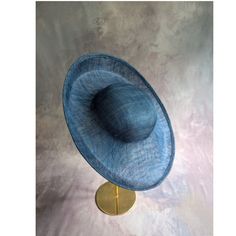 One sinamay straw hatinator base with an upturned brim in dark blue / light navy that measures approximately 15" (38cm) in diameter. Crown is approximately 3" (7.6cm) high. The edges of the brim are finished in wired sinamay. The multi-layer stiffened sinamay straw has a great sturdy weave and provides excellent support for your millinery creations. Sinamay is a natural material and you will see occasional beige / brown fibers / striations in the weave. This is not a defect, but is the result of how different natural fibers respond to dye and processing. This is NOT a ready to wear finished hat and will not stay on your head unless you add a head band or elastic to wear. This base does have a small sleeve sewn into the crown that will accomodate headbands listed separately in my shop. Add Formal Sinamay Brimmed Boater Hat, Blue Adjustable Fedora For Kentucky Derby, Adjustable Curved Brim Boater Hat For Church, Navy Formal Hat With Curved Brim, Navy Curved Brim Formal Hat, Formal Blue Fedora Hat, Blue Top Hat With Curved Brim For Formal Occasions, Blue Curved Brim Top Hat For Formal Occasions, Adjustable Wide Brim Boater Hat For Church