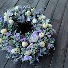 a wreath with eggs and flowers on a wooden floor