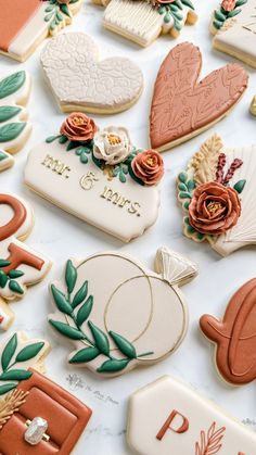 many decorated cookies on a table with flowers and other items in the shape of hearts